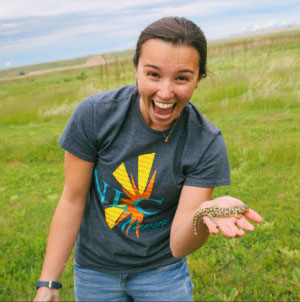 Tia holds a salamander that emerged from a prairie dog hole while cleaning up the painting project.